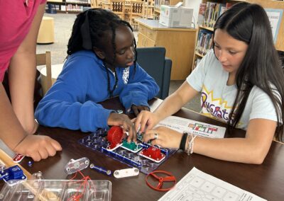 Youth participants work together on an electronics circuit kit during a STEM activity