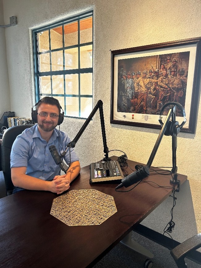 Podcast1 Museum staff member seated at a podcast recording desk